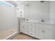Bathroom featuring dual sinks, white cabinetry, shower with tiled walls and flooring at 95 Purslane Dr, Franklinton, NC 27525