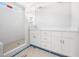 Bright bathroom with double sinks, white cabinets, and a tiled shower featuring a shower niche at 95 Purslane Dr, Franklinton, NC 27525
