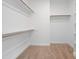 Walk-in closet featuring carpeted floor, wooden rods, and white shelving at 95 Purslane Dr, Franklinton, NC 27525