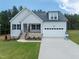 Charming home featuring a stone foundation, gray siding, black shutters, and a two-car garage at 95 Purslane Dr, Franklinton, NC 27525