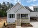 Charming single-Gathering home featuring stone accents, gray siding, attached garage, and a welcoming front porch at 95 Purslane Dr, Franklinton, NC 27525