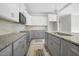 Bright kitchen with white upper cabinets, gray lower cabinets, and granite countertops and stainless steel appliances at 95 Purslane Dr, Franklinton, NC 27525