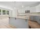 Kitchen featuring granite countertops, stainless steel microwave, white cabinets, and wood-look flooring at 95 Purslane Dr, Franklinton, NC 27525