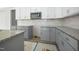 New kitchen featuring white upper cabinets and gray lower cabinets with stainless steel appliances at 95 Purslane Dr, Franklinton, NC 27525