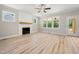 Bright living room features a cozy fireplace with wooden mantle and large windows at 95 Purslane Dr, Franklinton, NC 27525