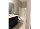 Bright bathroom featuring a black vanity with a large mirror and a well-maintained shower and tub at 108 Kaspurr Dr, Garner, NC 27529