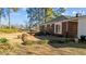 Backyard with a brick patio, mature trees, garden beds and brick house at 205 N Augusta Ave, Benson, NC 27504