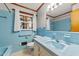 Bathroom featuring blue tile, updated fixtures, vanity, sink, toilet, window and full tub and shower combination at 205 N Augusta Ave, Benson, NC 27504