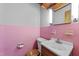 Retro bathroom featuring pink tiles, a white sink, and classic fixtures at 205 N Augusta Ave, Benson, NC 27504