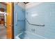Bathroom featuring blue tile, updated fixtures, grab bars and a full tub and shower combination at 205 N Augusta Ave, Benson, NC 27504