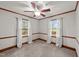 Carpeted bedroom with painted walls, wood trim, a ceiling fan and windows with curtains at 205 N Augusta Ave, Benson, NC 27504