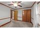 Carpeted bedroom with painted walls, wood trim, a ceiling fan and closet with wood doors at 205 N Augusta Ave, Benson, NC 27504