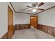 Carpeted bedroom with painted walls, wood trim, a ceiling fan and wood paneling at 205 N Augusta Ave, Benson, NC 27504