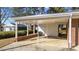 Attached carport featuring white pillars, a brick base, and access to an exterior door at 205 N Augusta Ave, Benson, NC 27504