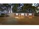 Charming brick home with a covered carport, a well-manicured lawn, and mature trees at 205 N Augusta Ave, Benson, NC 27504