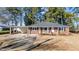 Charming brick home with a covered carport and a well-maintained front lawn surrounded by mature trees at 205 N Augusta Ave, Benson, NC 27504