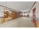 Spacious carpeted living room showcasing a brick fireplace, decorative wood paneling, and bright natural light at 205 N Augusta Ave, Benson, NC 27504