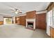 Cozy living room featuring a brick fireplace, carpeted floors, and wood paneling at 205 N Augusta Ave, Benson, NC 27504