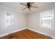 Well-lit bedroom featuring hardwood floors and two windows at 2540 Mayo Lake Rd, Roxboro, NC 27574