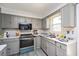 Kitchen with grey cabinets, stainless steel range, and vinyl flooring at 2540 Mayo Lake Rd, Roxboro, NC 27574