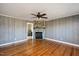 Living room features hardwood floors, stone fireplace, and ceiling fan at 2540 Mayo Lake Rd, Roxboro, NC 27574