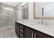 Bathroom featuring double vanities with quartz countertops and a separate tiled shower with glass door at 316 Church St, Morrisville, NC 27560