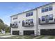 Rear exterior of townhomes featuring balconies, black framed windows, and black garages at 316 Church St, Morrisville, NC 27560