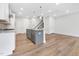 Open-concept living space with kitchen island, stainless appliances, and hardwood floors at 316 Church St, Morrisville, NC 27560