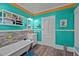 Bright bathroom with a standalone tub, turquoise walls, wood-look floor, and modern fixtures at 400 S Boddie St, Nashville, NC 27856