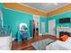 A brightly colored bedroom with orange and turquoise walls features a desk, dresser, and fireplace at 400 S Boddie St, Nashville, NC 27856