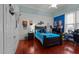 Bedroom features a dark wood bed with blue bedding, red floors, and a sports themed design at 400 S Boddie St, Nashville, NC 27856