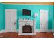 Living room fireplace is set between two doors with bright turquoise walls and a TV at 400 S Boddie St, Nashville, NC 27856