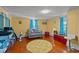 Inviting living room with yellow walls, hardwood floors, and a cozy gray loveseat at 400 S Boddie St, Nashville, NC 27856
