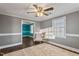 Neutral living room featuring a ceiling fan, wood flooring, and large window with natural light at 408 W Main St, Pine Level, NC 27568