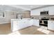 Modern kitchen features white cabinets, stainless steel appliances, and a large island at 5317 Ten Ten Rd, Apex, NC 27539