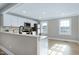 Modern kitchen with white cabinets, stainless steel appliances, and breakfast bar at 5317 Ten Ten Rd, Apex, NC 27539