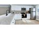 Updated kitchen featuring white cabinets, stainless steel appliances, and marble countertops at 5317 Ten Ten Rd, Apex, NC 27539