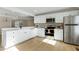 Modern kitchen with white shaker cabinets, stainless steel appliances and marble countertops at 5317 Ten Ten Rd, Apex, NC 27539