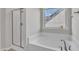 Bathroom featuring a walk-in shower, soaking tub, and large window that provides ample natural lighting at 664 Long Melford Dr, Rolesville, NC 27571