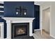 Close-up of a fireplace with a white mantel and blue accent wall. TV mount above the fireplace at 664 Long Melford Dr, Rolesville, NC 27571