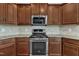 Close up of the stainless oven, microwave and cooktop in this modern kitchen at 664 Long Melford Dr, Rolesville, NC 27571