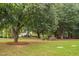 Landscaped backyard with lush trees and a wooden bench at 7440 Bleasdale Ct, Apex, NC 27539