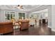 Open living room with hardwood floors, a stone fireplace, and built-in shelving at 7440 Bleasdale Ct, Apex, NC 27539