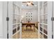 Home office with a wooden desk and French doors at 7440 Bleasdale Ct, Apex, NC 27539