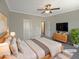 Virtually staged bedroom with large bed, dresser, and TV at 902 Laurel Gate Dr, Wake Forest, NC 27587