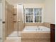 Elegant bathroom with separate shower and soaking tub next to a window at 9412 Harvest Acres Ct, Raleigh, NC 27617