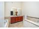 Bathroom showcasing a vanity, soaking tub, tiled walls and flooring, and vanity lighting at 9412 Harvest Acres Ct, Raleigh, NC 27617