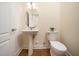 Powder room with pedestal sink, toilet, and tile flooring offers convenience for guests at 9412 Harvest Acres Ct, Raleigh, NC 27617