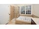 Elegant bathroom with separate shower and soaking tub next to a window at 9412 Harvest Acres Ct, Raleigh, NC 27617