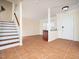 Foyer featuring tile floors, stairway, and built-in bar, creating a welcoming entrance to the home at 9412 Harvest Acres Ct, Raleigh, NC 27617